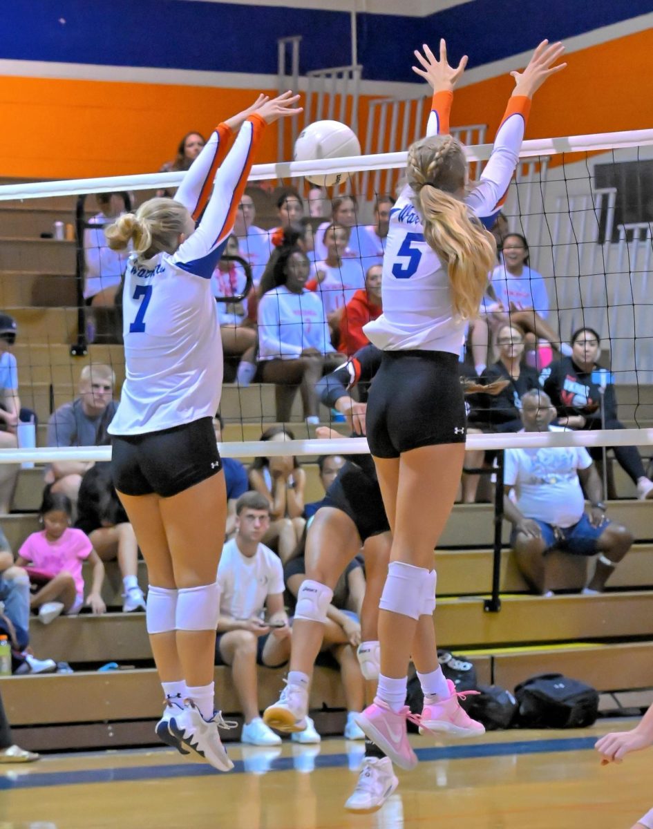 The volleyball team blocks a shot during one of the games during this successful season.