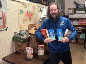 Mr. Sadler holds donations from students.